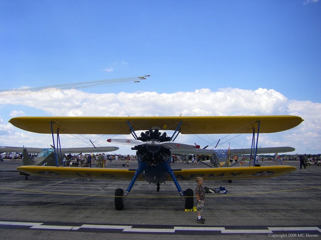 Boeing PT-17 Stearman, T6 formation passing in the distance.