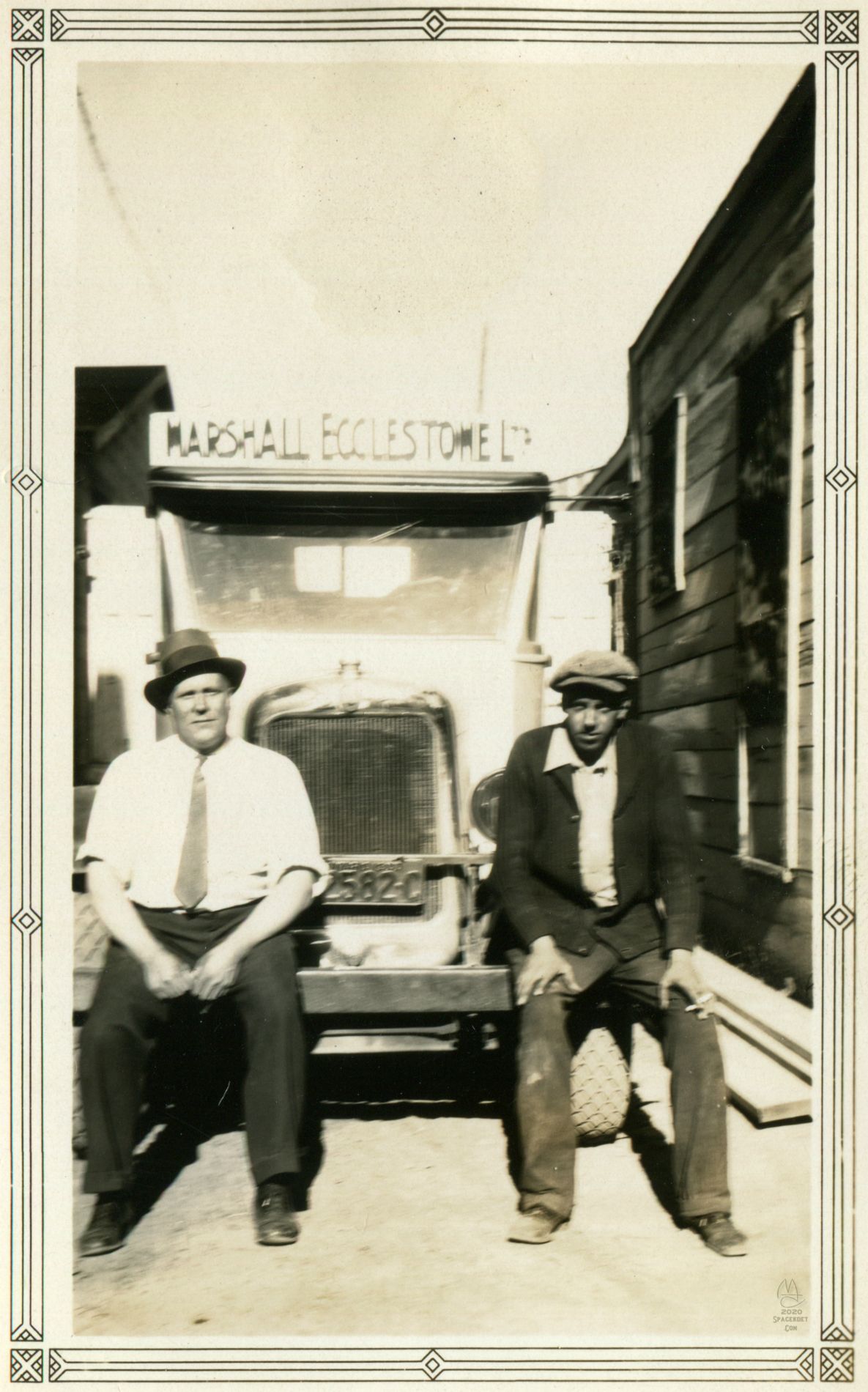 Grandpa (left) and presumably a co-worker sitting on the work truck.